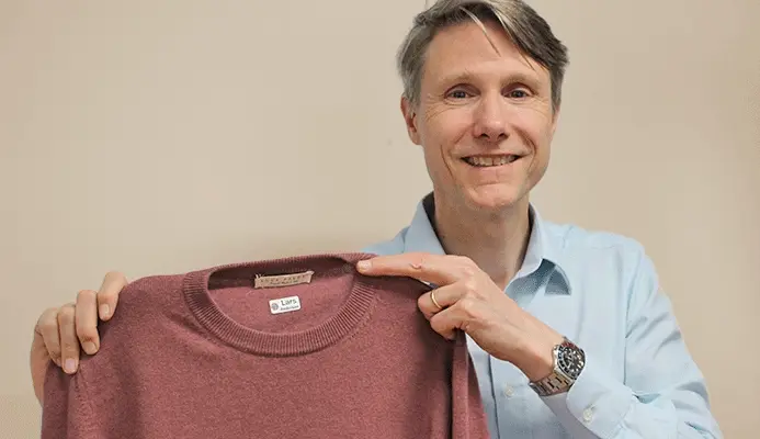 Lars B. Andersen, fondateur de My Nametags, montrant un pull bordeaux avec une étiquette thermocollante « Lars » à l'intérieur du col